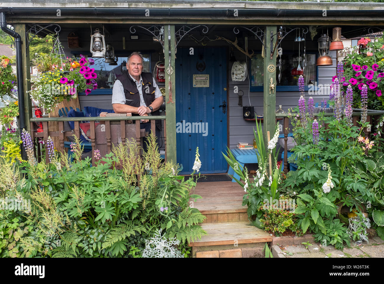 Portrait von Jim und seine Hausgemachte bothy im Garten seines Hauses. Stockfoto