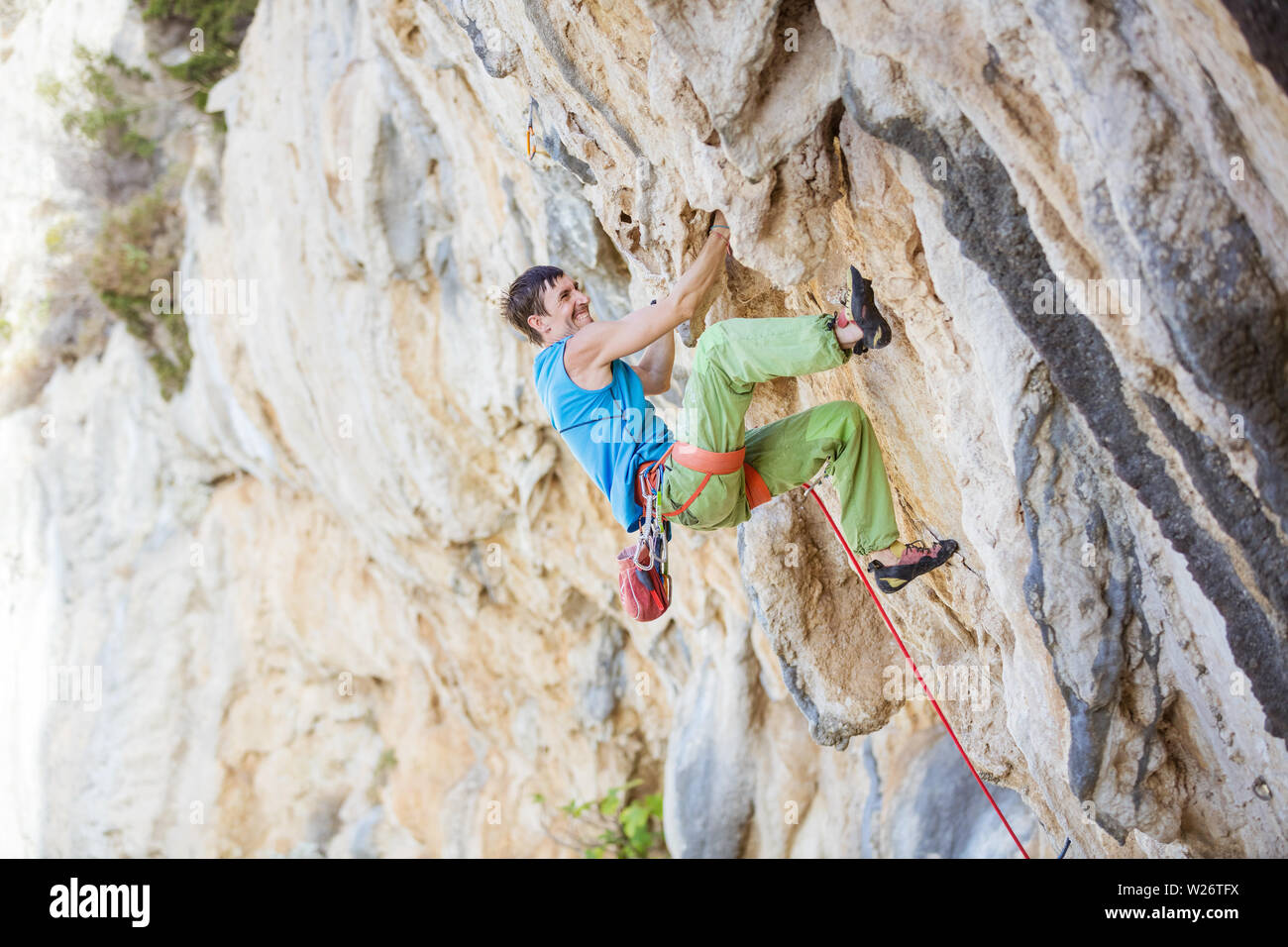 Junger Mann klettern anspruchsvolle Strecke auf überhängenden Klippe Stockfoto