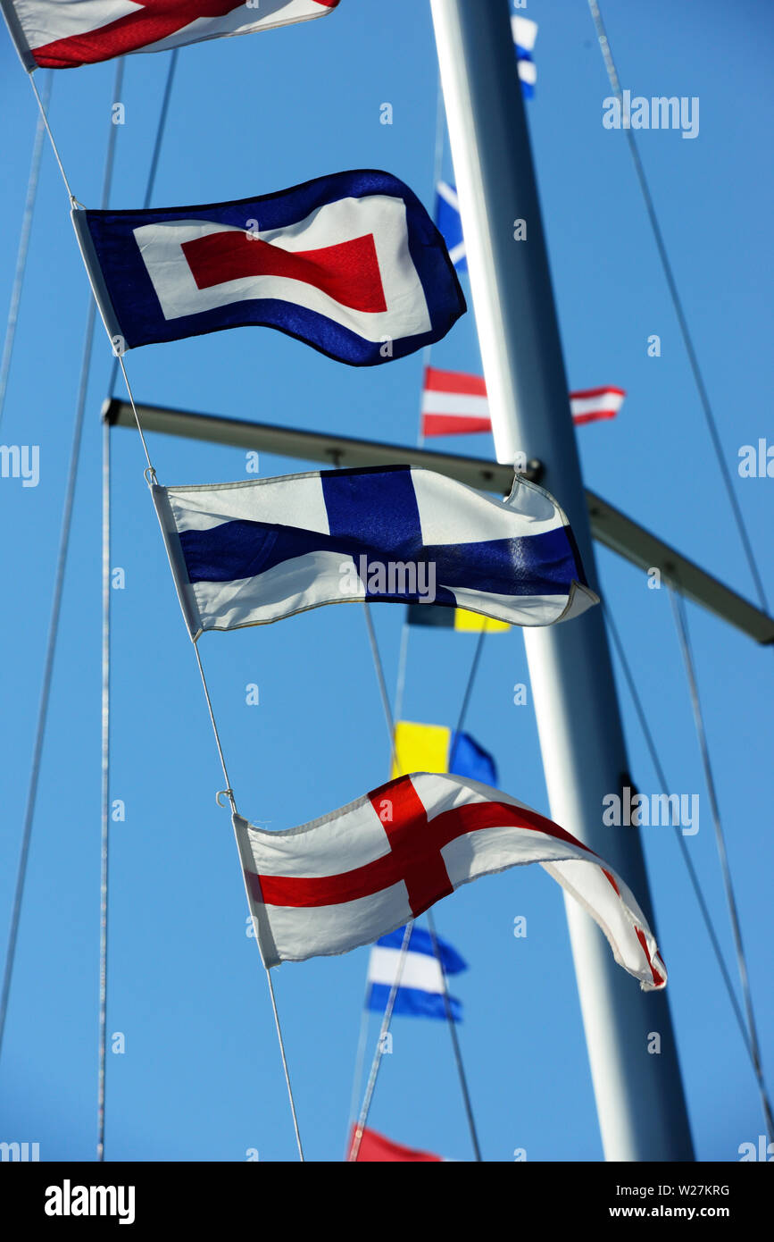 Meer Flaggen im Wind flattern vor blauem Himmel Stockfoto