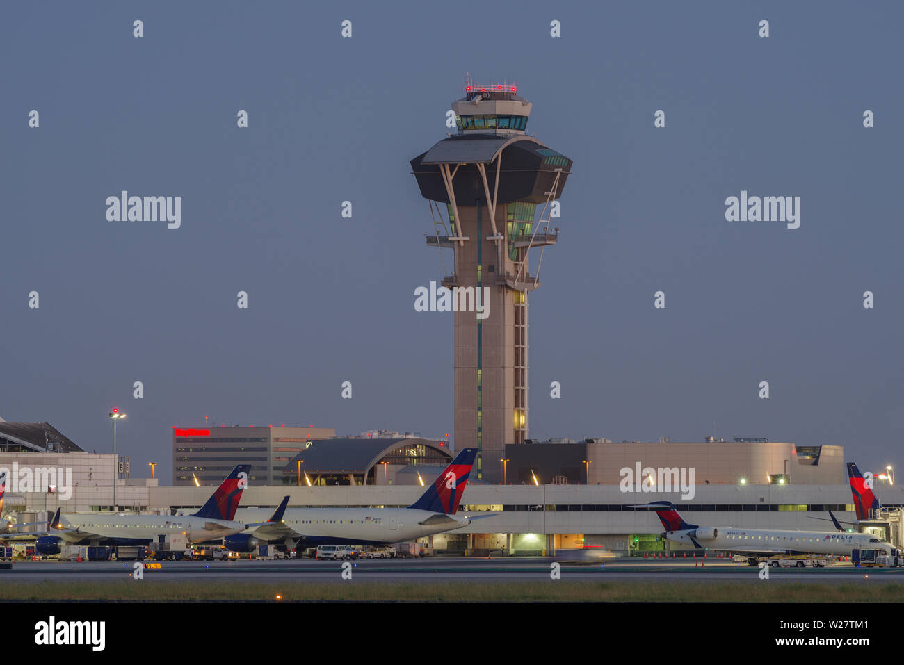 Bild der Control Tower und Delta Air Lines jets am Tor am internationalen Flughafen von Los Angeles, LAX, in der Dämmerung. Stockfoto