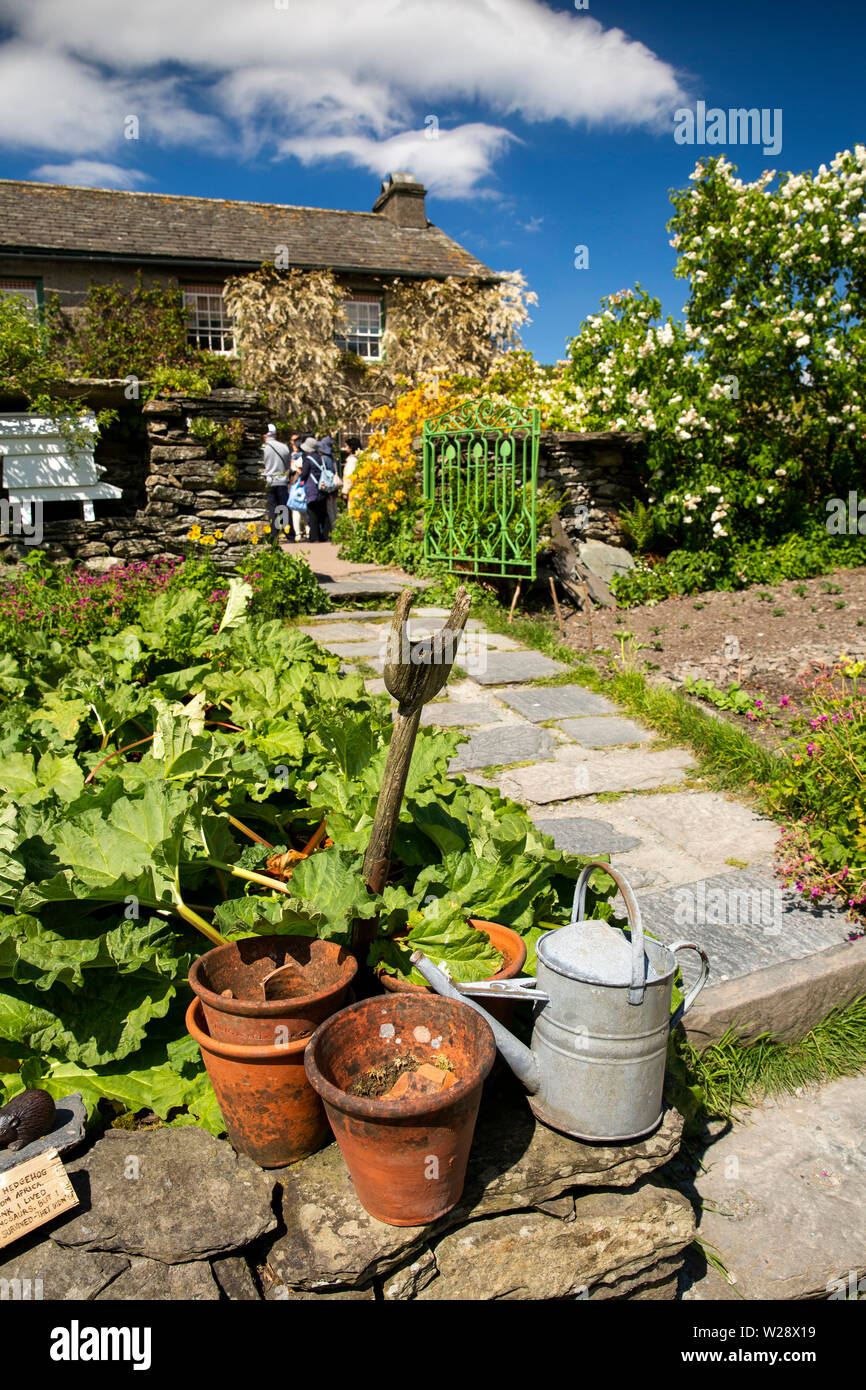 UK, Cumbria, Hawkshead, Near Sawrey, Hill Top Farm, Beatrix Potter's Home, Gemüsegarten, Spaten, Blumentöpfe und Gießkanne bei Rhabarber Büschel Stockfoto