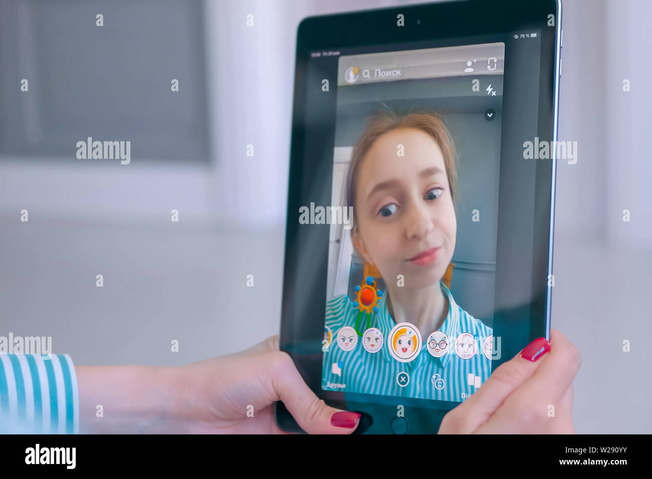 Frau mit Snapchat Multimedia Messaging App mit Gesichtsmaske auf Tablet Stockfoto