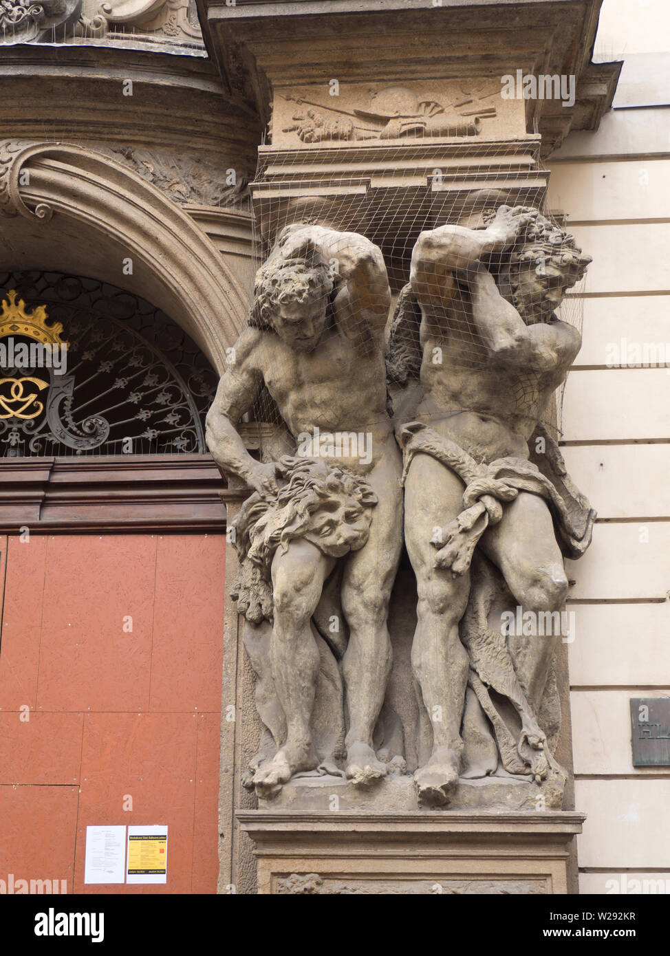 Fassade Kunst, Skulpturen von zwei starke Männer, die eine Spalte auf einer Fassade in Stare Mesto, Prag Tschechische Republik Stockfoto