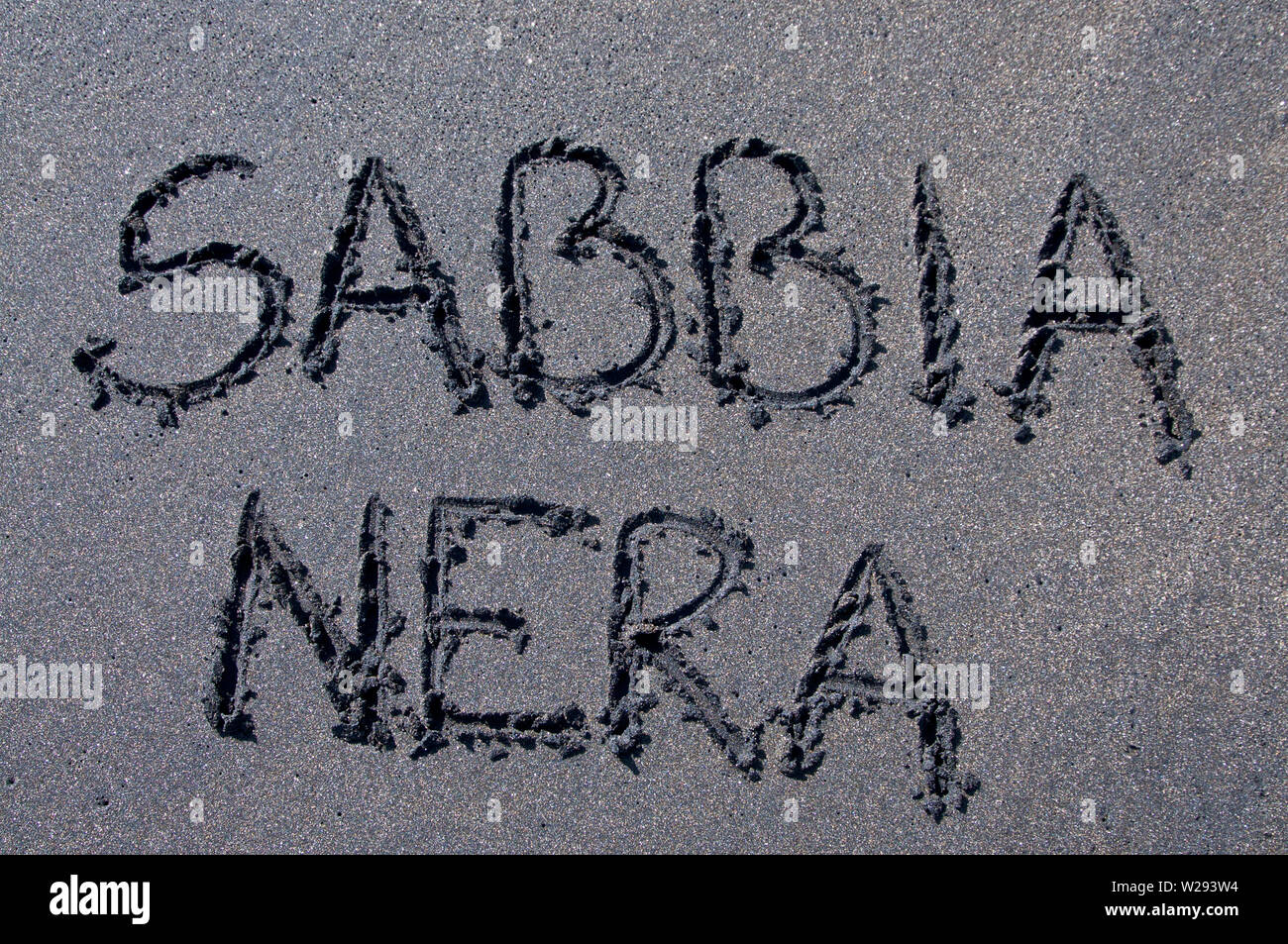 Der italienische Text abbia Nera" (schwarzer Sand) Inschrift auf einem schwarzen Sandstrand in der Nähe von Canggu, Bali - Indonesien gezogen Stockfoto