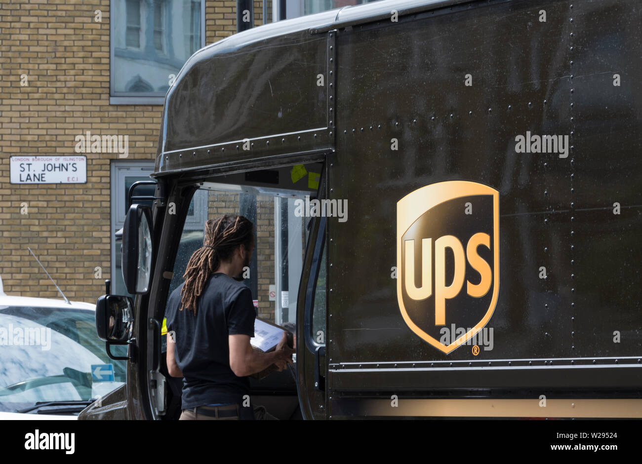 Ein UPS-Lieferwagen (United Parcel Service) und Fahrer auf den Straßen von London, England, Großbritannien Stockfoto