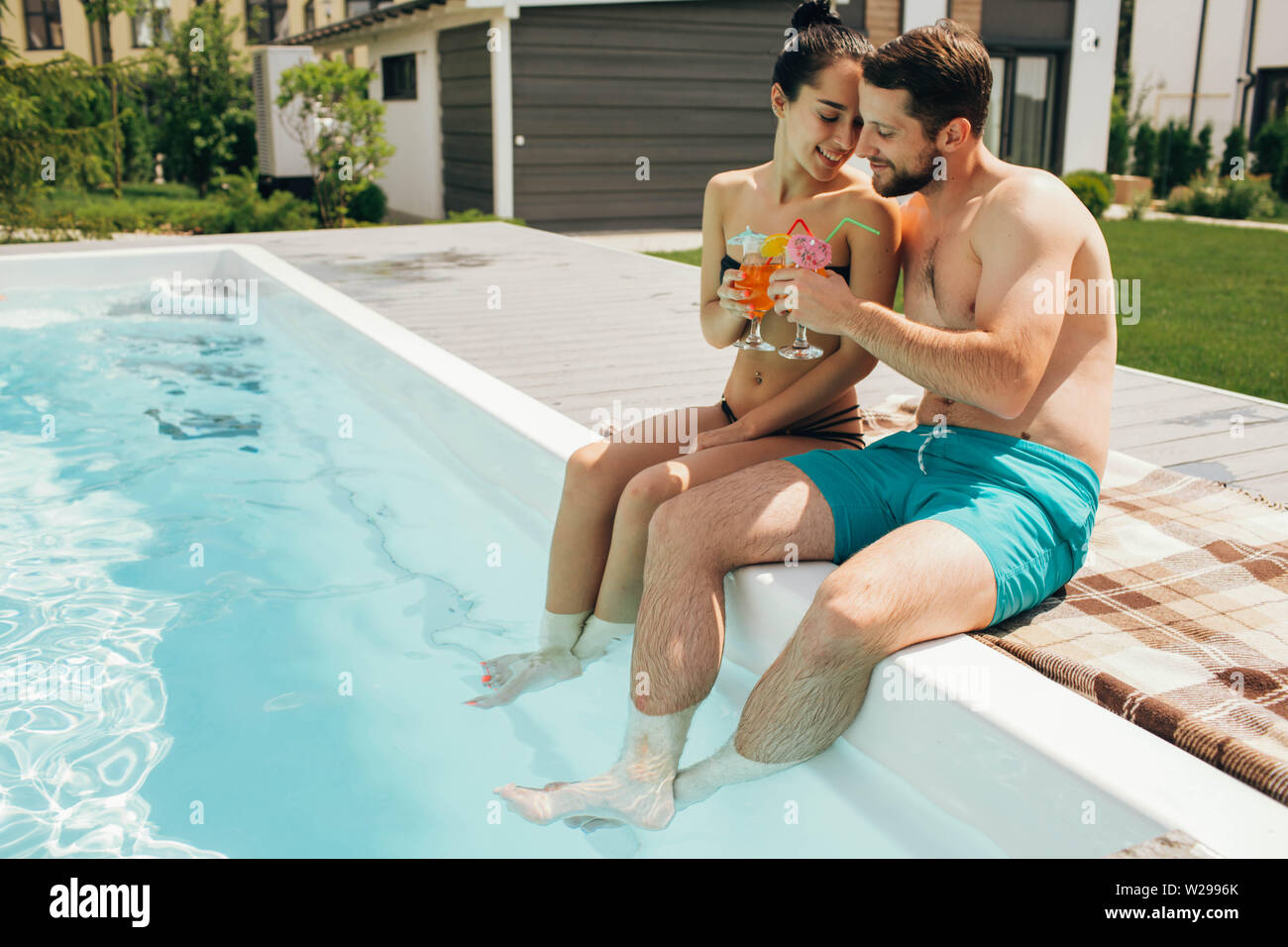 Schöne heteroseksual paar Sommer ausruhen. Der Mann und die Frau sitzen in der Nähe von Pool und mit frischen Cocktail Stockfoto