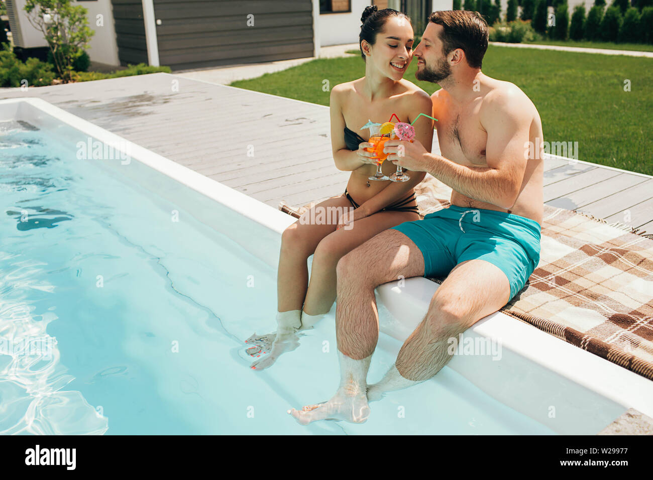Schöne heteroseksual paar Sommer ausruhen. Der Mann und die Frau sitzen in der Nähe von Pool und mit frischen Cocktail Stockfoto