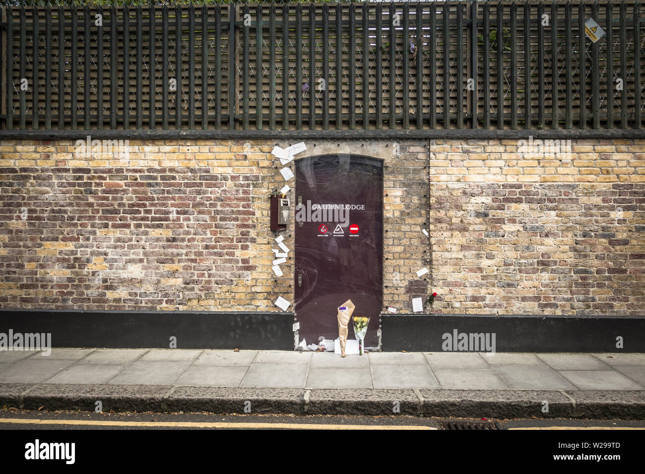 Handgeschriebene Tribute und Blumensträuße, die vor einer jetzt desinfizierten Garden Lodge platziert wurden - Freddie Mercury's ehemaliges Haus am Logan Place, West London, Stockfoto