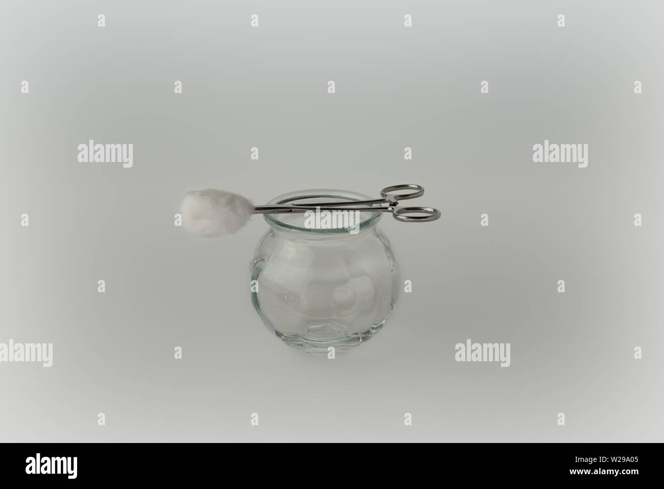 Fire Cup mit Zange holding Watte ruht auf der Schale Stockfoto