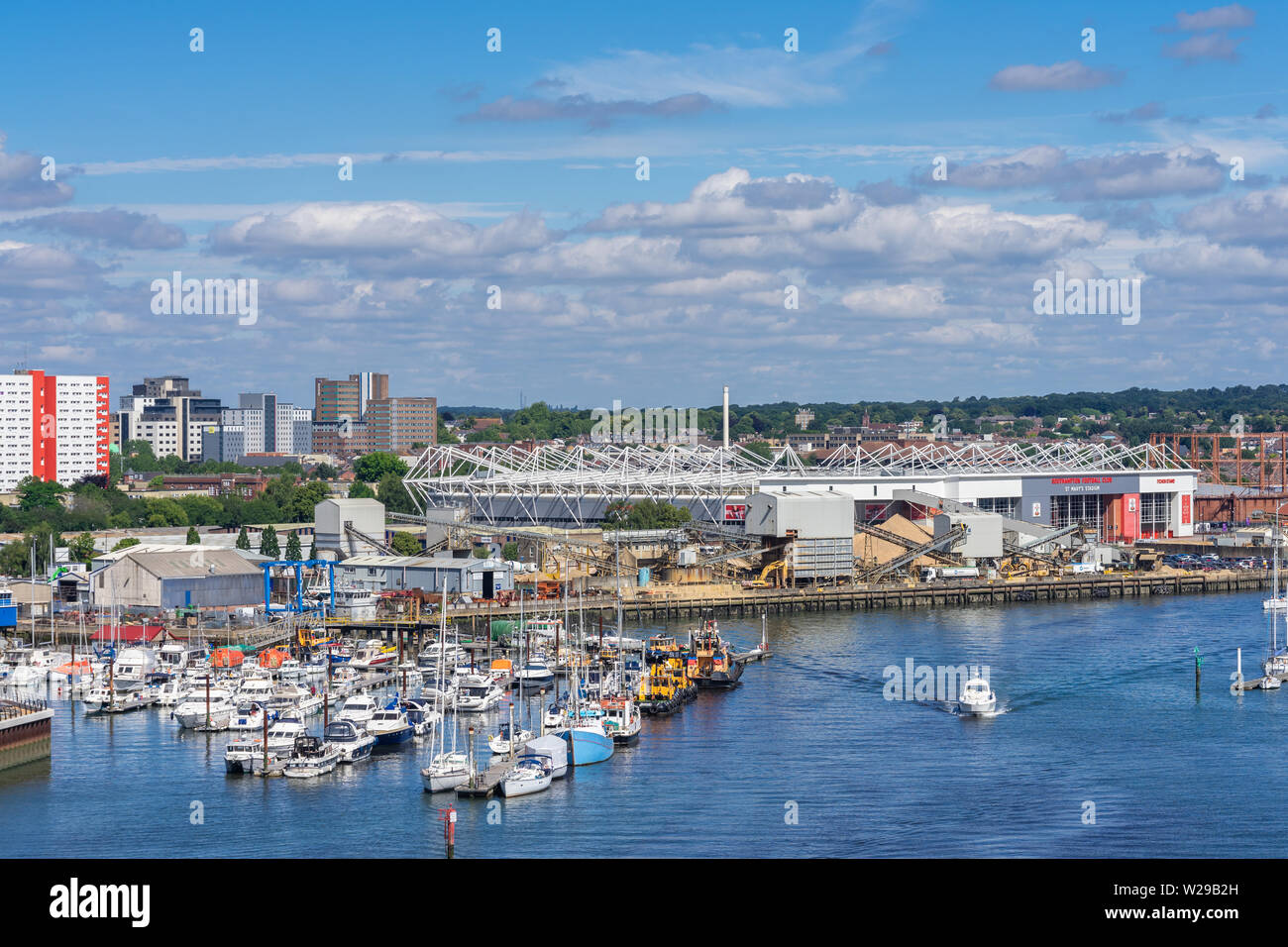 Boote geschleppt entlang der Itchen River mit Fußball-Stadion des St Mary im Hintergrund, Blick von itchen Brücke, Southampton, England, Großbritannien Stockfoto