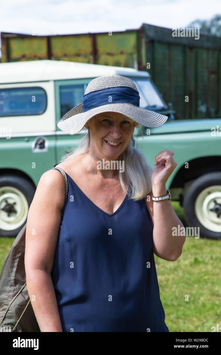 90 Kent County zeigen, Detling, 6. Juli 2019. Frau in einen Strohhut trägt ein blaues Top steht vor einem Landrover. Stockfoto