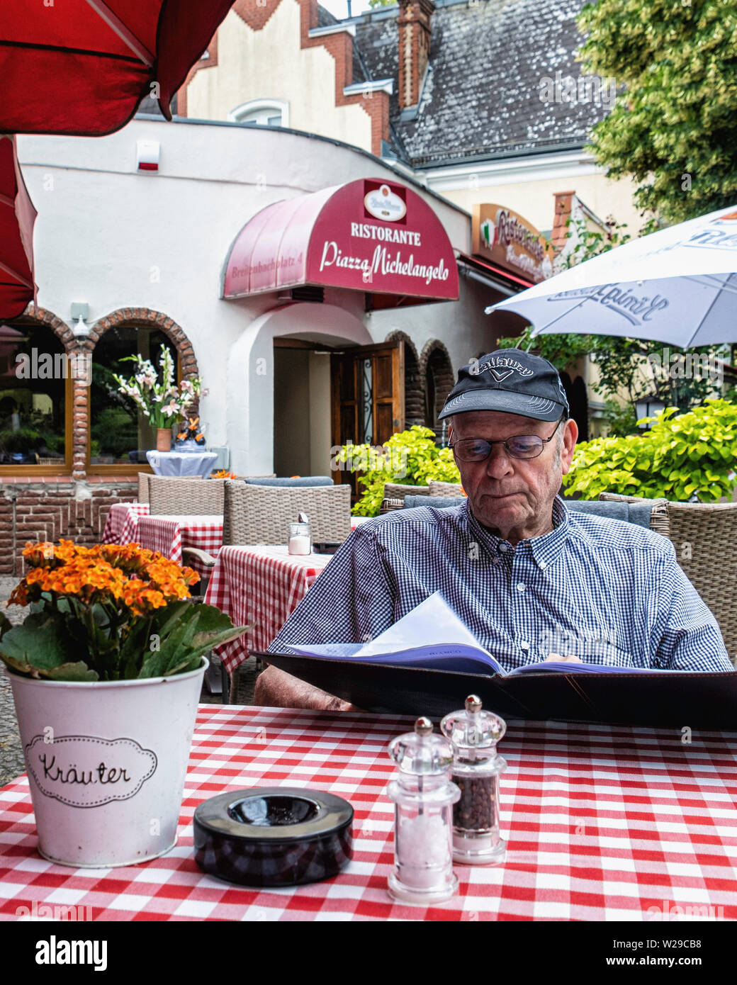 Ristorante Piazza Michelangelo. Älterer mann Lesung im Italienischen Restaurant mit italienischer Küche auf Breitenbachplatz, Berlin-Zehlendorf Stockfoto