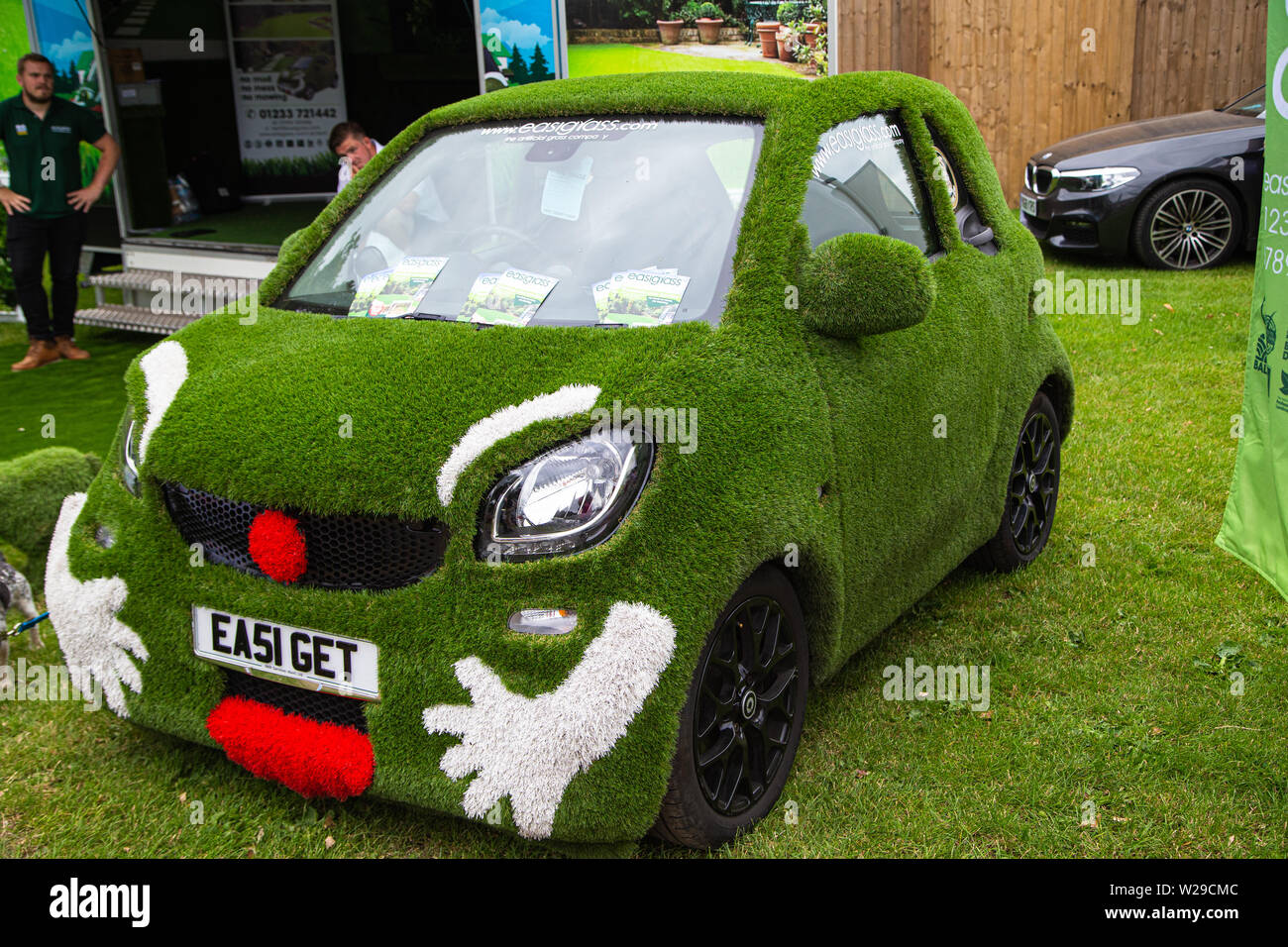 90 Kent County zeigen, Detling, 6. Juli 2019. Ein Auto in Gras und einem Gesicht, der Werbung für ein Unternehmen. Stockfoto