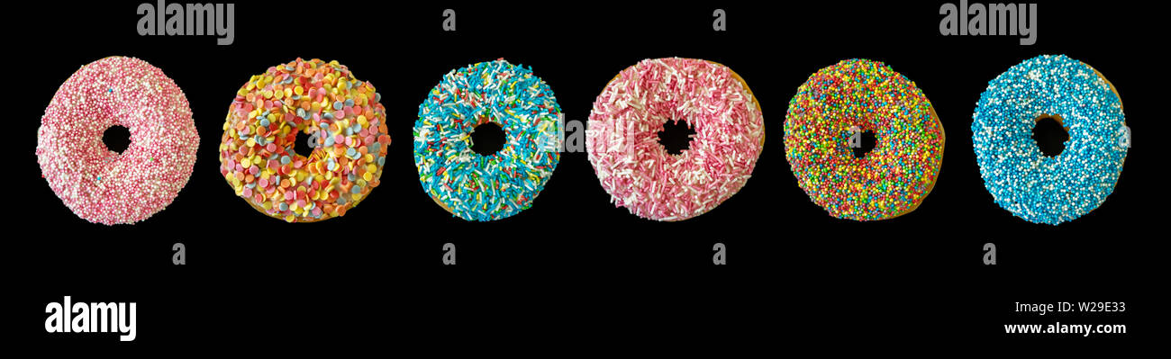 Sortierte Donuts. Bunte donut Collage auf schwarzem Hintergrund. Ansicht von oben, Banner Stockfoto