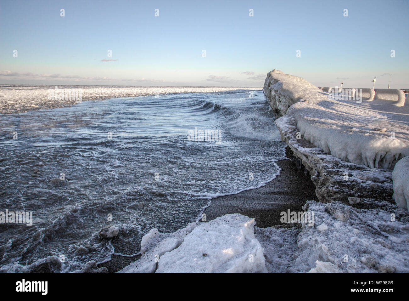 Winter auf den Großen Seen. Gefrorene Küste, Eis und Wellen entlang der Küste des Lake Huron in der Nähe von Port Sanilac, Michigan. Stockfoto