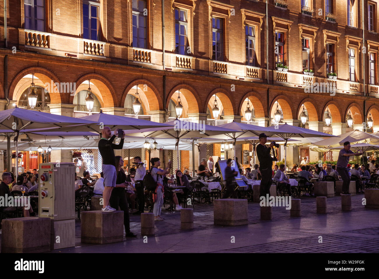 Touristen fotografieren am Place du Capitole in Toulouse (Frankreich) bei Nacht Stockfoto