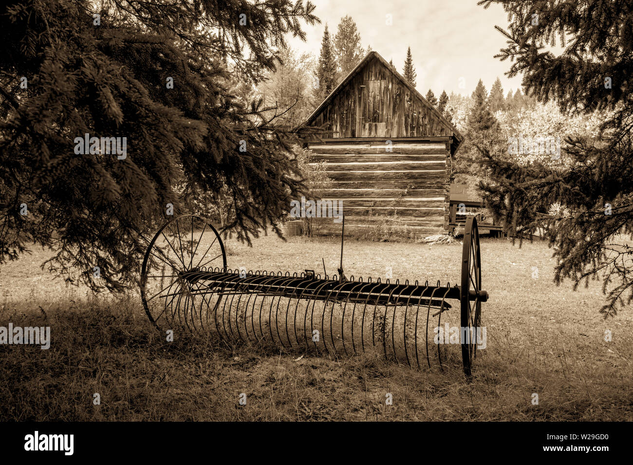 Pioneer Homestead. Antike verrostete Pflug und Außenwand eines traditionellen Hütte im amerikanischen Mittelwesten anmelden Stockfoto