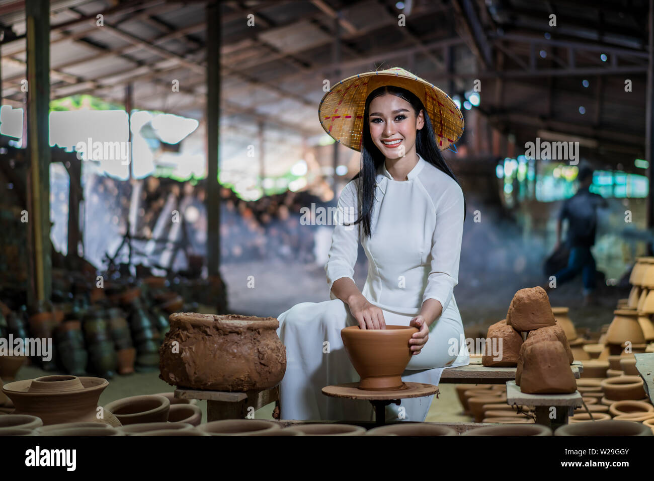 Handwerker der Frauen in der Vietnamesischen weiße Kleider und lokalen Weisheit Keramik erstellen Gläser und Vorbereitung im Brennofen brennen Stärke zu erstellen Stockfoto