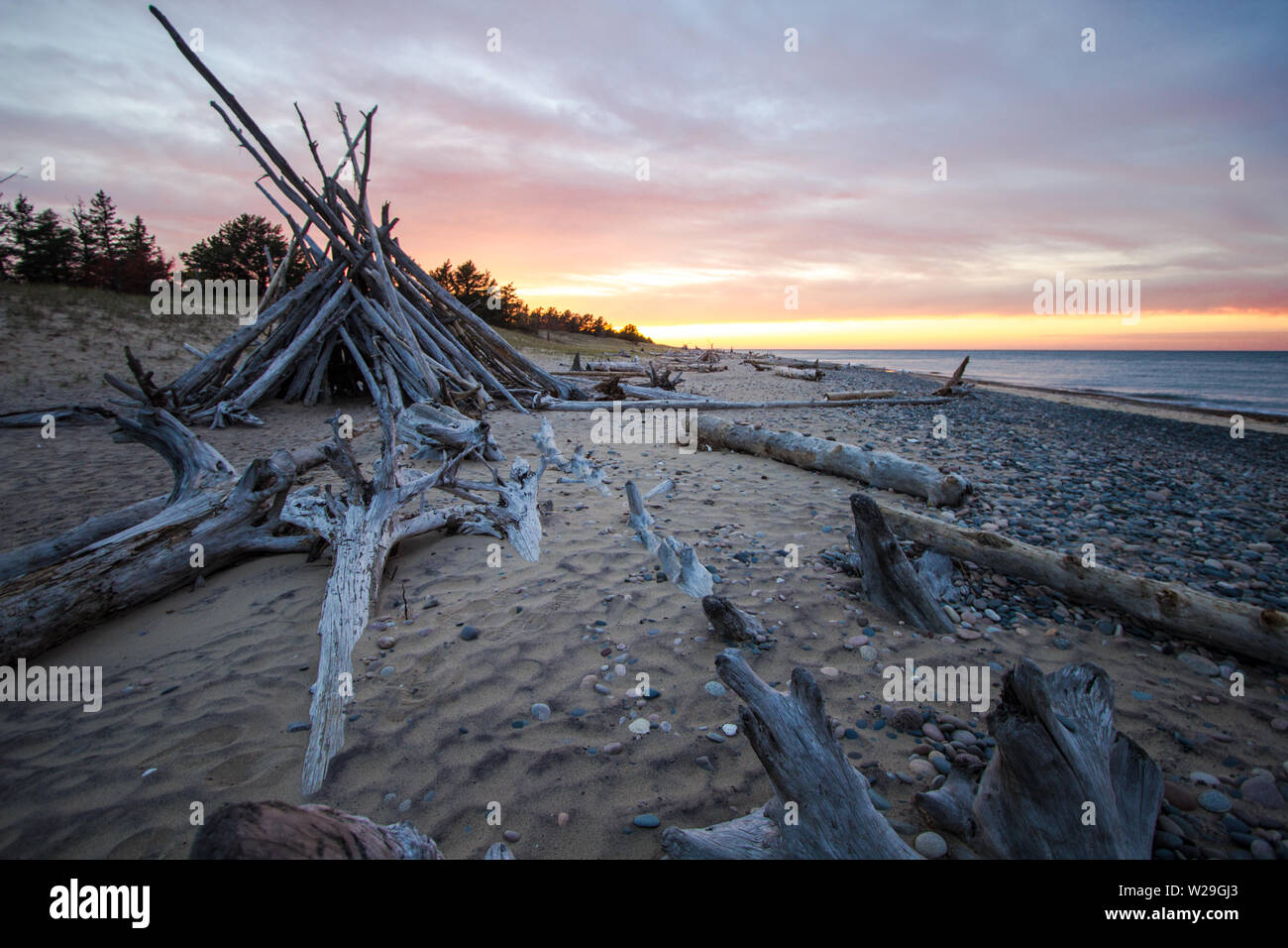 Driftwood Beach Sonnenuntergang. Sonnenuntergang an der Küste des Lake Superior in Whitefish Point mit einem primitiven Strandhütte. Stockfoto