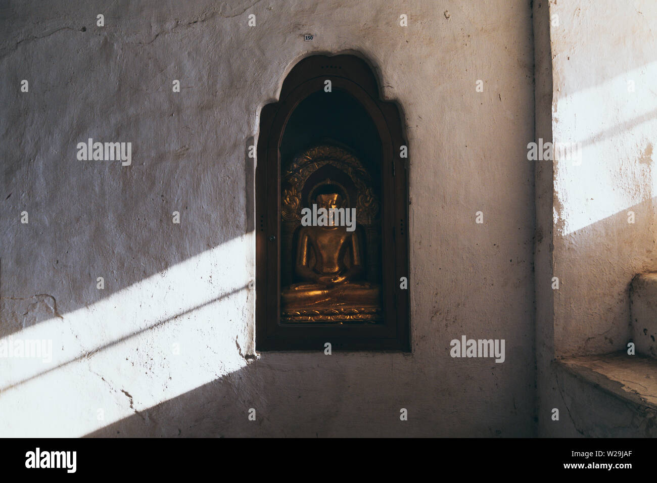 Buddha Statue im Ananda Tempel geschnitzt in der Wand. Licht aus dem Fenster. Stockfoto
