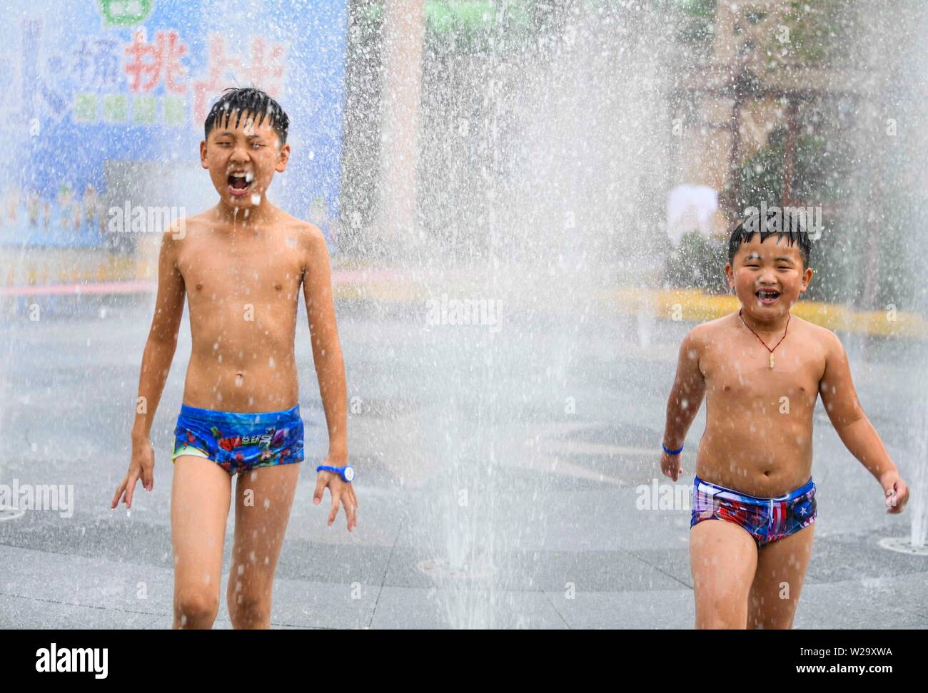 China. 07 Juli, 2019. (190707) - BOZHOU, Juli 7, 2019 (Xinhua) - Kinder spielen mit Wasser in einem Park in Bozhou, im Osten der chinesischen Provinz Anhui, Juli 7, 2019. Menschen in ganz China abkühlen lassen sich auf verschiedene Art und Weise während der Xiaoshu, oder weniger Wärme, die 11 der 24 solar Begriffe Was bedeutet der Beginn der heissen Sommer. Quelle: Xinhua/Alamy leben Nachrichten Stockfoto