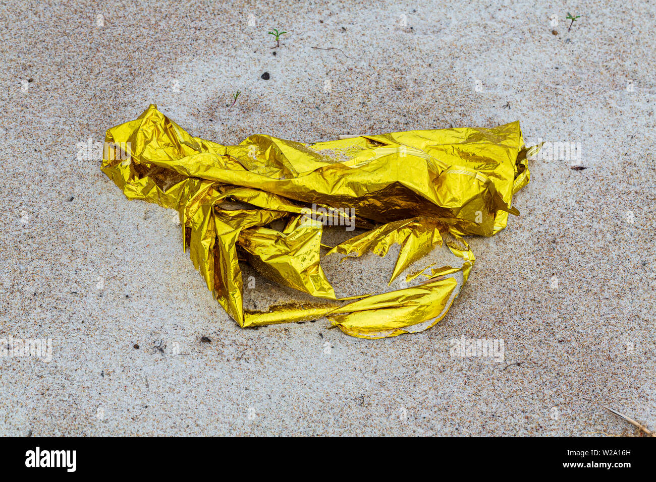 Umweltverschmutzung - golden Rettungsdecke liegen am Strand Stockfoto