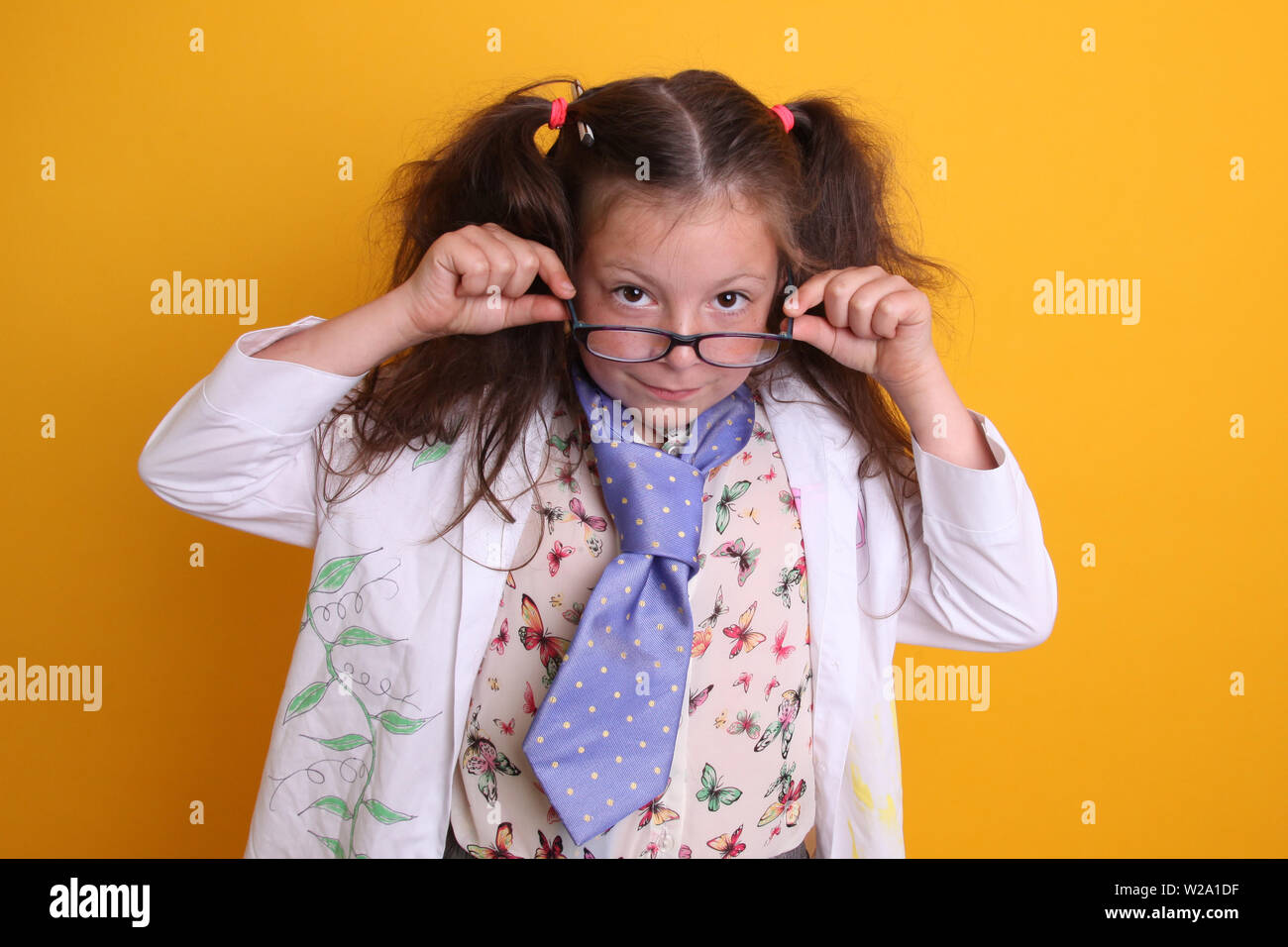Herr - Wissenschaft Geek junge Mädchen/Frauen in Gläsern Alter 7 - Kind Wissenschaftler über Gläser an Kamera suchen auf gelbem Hintergrund Stockfoto