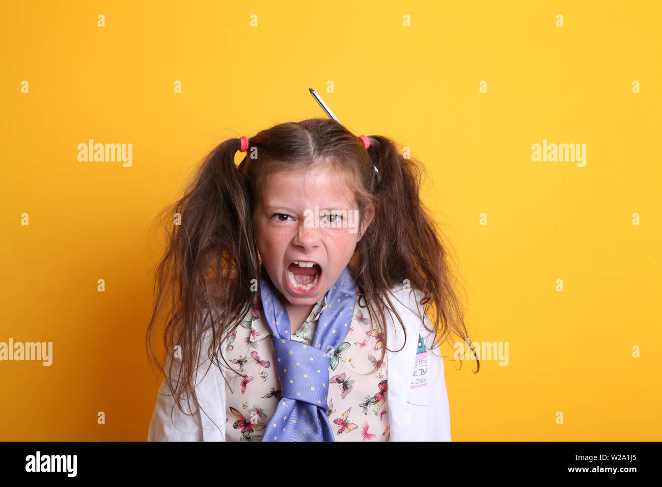 MR - Science Young Little Girl / Weiblich - Alter 7 - wütend Kind schreiend Mund weit offen bei der Kamera Auf gelbem Hintergrund Stockfoto