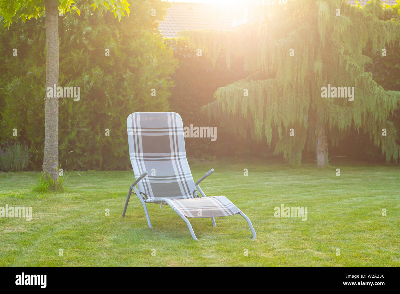 Liege Stuhl auf grünen Gras im Garten Stockfoto