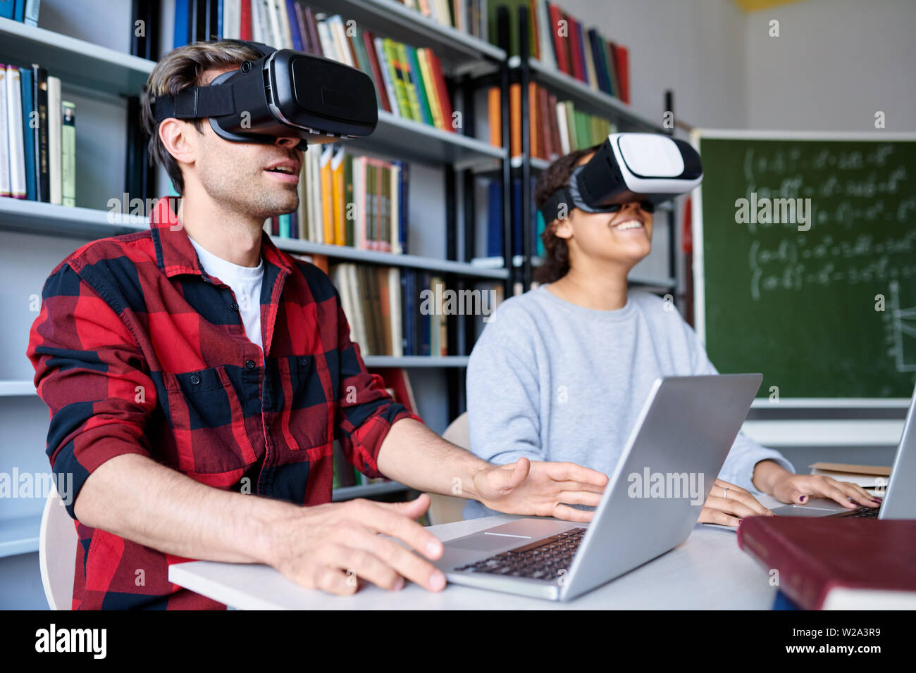 Zwei junge Studenten in VR-Headsets, virtuelle Präsentation Stockfoto