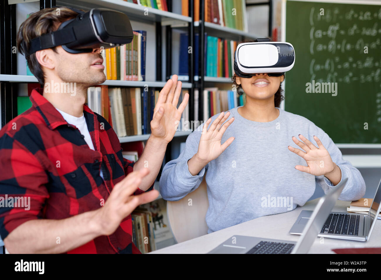 Junge erstaunt der Mann und die Frau in der VR-Headsets in virtuelle Erfahrung Stockfoto