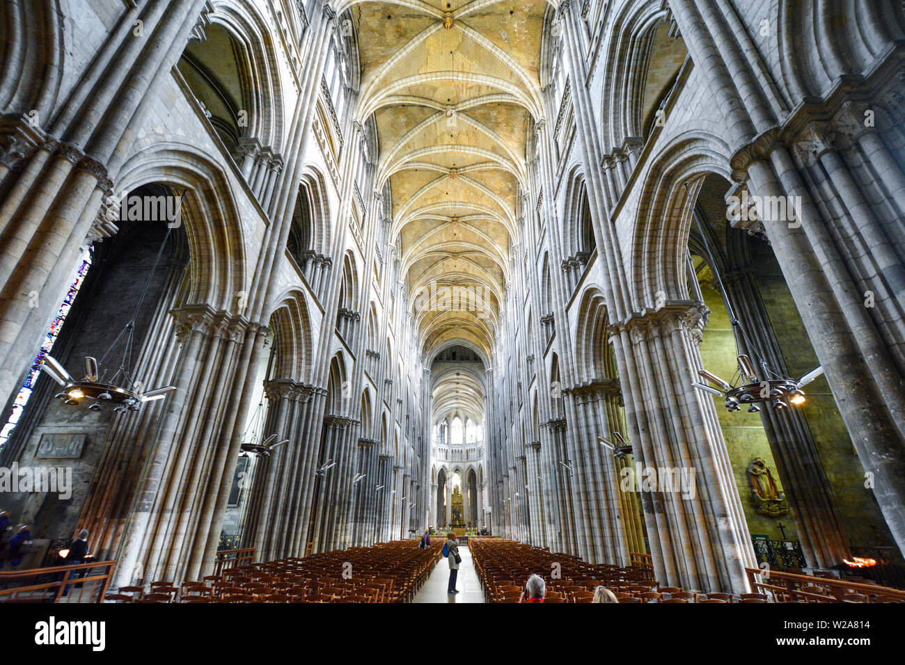 Touristen nehmen Fotos und sitzen in den Kirchenbänken und Langhaus der Kathedrale von Rouen, Frankreich Stockfoto