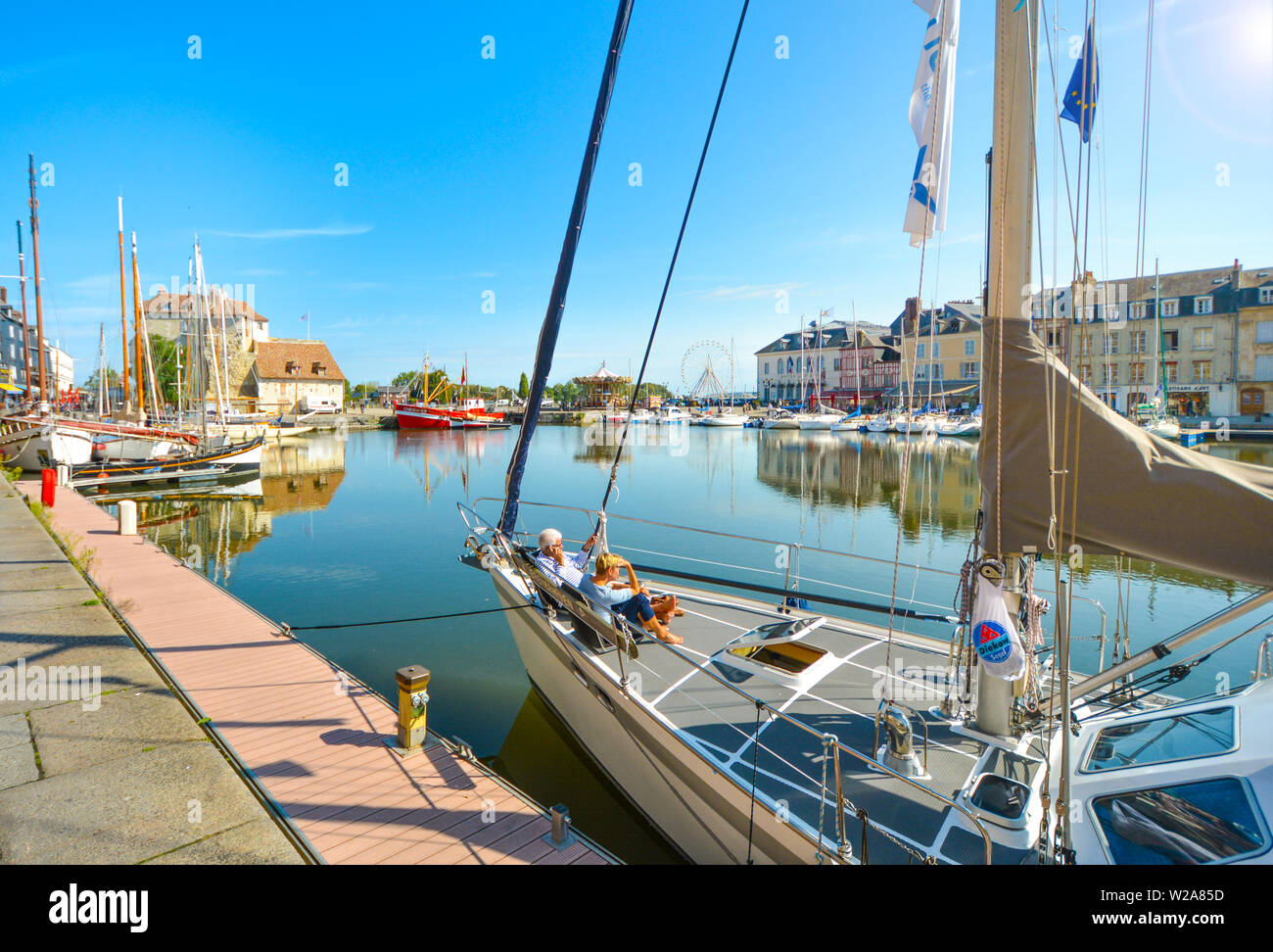 Ein Paar auf einem Segelboot im malerischen alten Pier Stadt Honfleur Frankreich an der Küste der Normandie entspannen Stockfoto