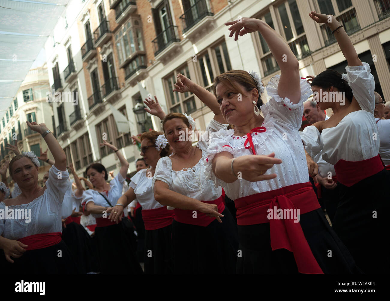 Frauen gekleidet in der Tracht der Tanz auf den Straßen von Marques de Larios während einer Leistung. Mehr als 4.730 Menschen auf der Straße versammelten sich zu einem neuen Weltrekord tanzen Flamenco, Flamenco Tanz Schule des Malaga als Teil der Ereignisse durch die Flamenco Biennale organisiert die Andalusien Kultur und Flamenco Tanz zu fördern. Stockfoto