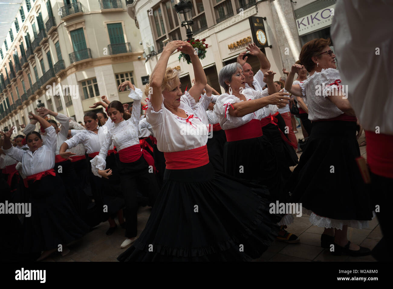 Frauen gekleidet in der Tracht der Tanz auf den Straßen von Marques de Larios während einer Leistung. Mehr als 4.730 Menschen auf der Straße versammelten sich zu einem neuen Weltrekord tanzen Flamenco, Flamenco Tanz Schule des Malaga als Teil der Ereignisse durch die Flamenco Biennale organisiert die Andalusien Kultur und Flamenco Tanz zu fördern. Stockfoto