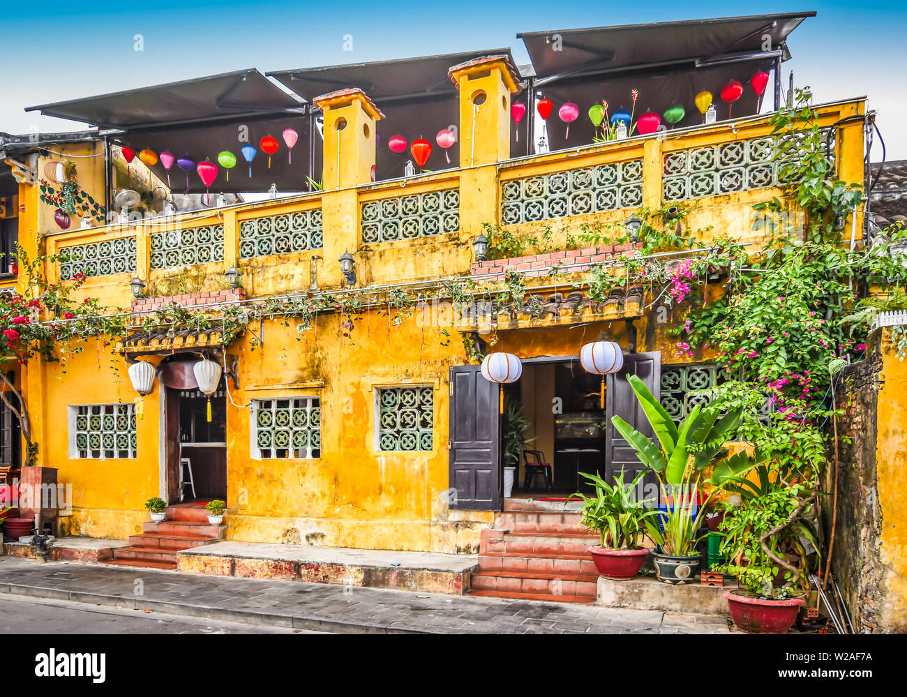 Helles gelbes Gebäude mit Laternen in der Altstadt von Hoi An, Vietnam, Asien. Stockfoto