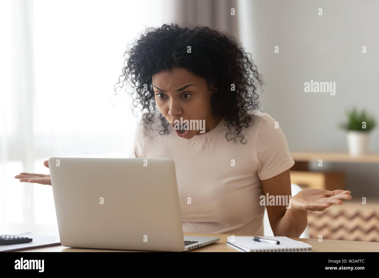 Verärgert betonte afrikanische Frau Kunden bei Laptop Bildschirm Geschockt Stockfoto
