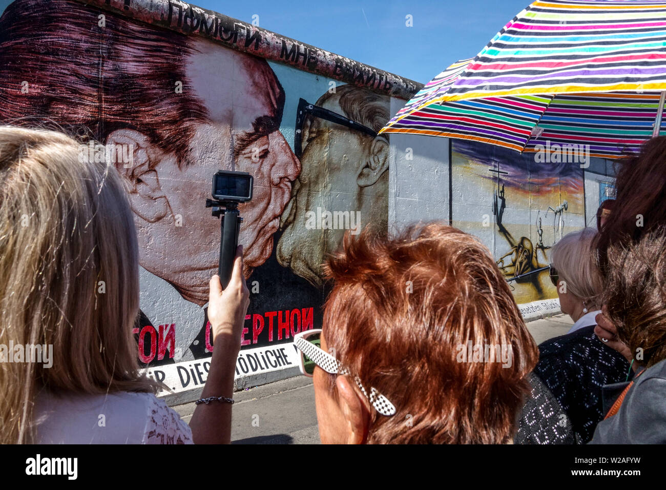 Breschnev Honecker Kuss, vier Damen beobachten es, East Side Wall Gallery, Berliner Mauer Touristen Deutschland Friedrichshain City Street Stockfoto