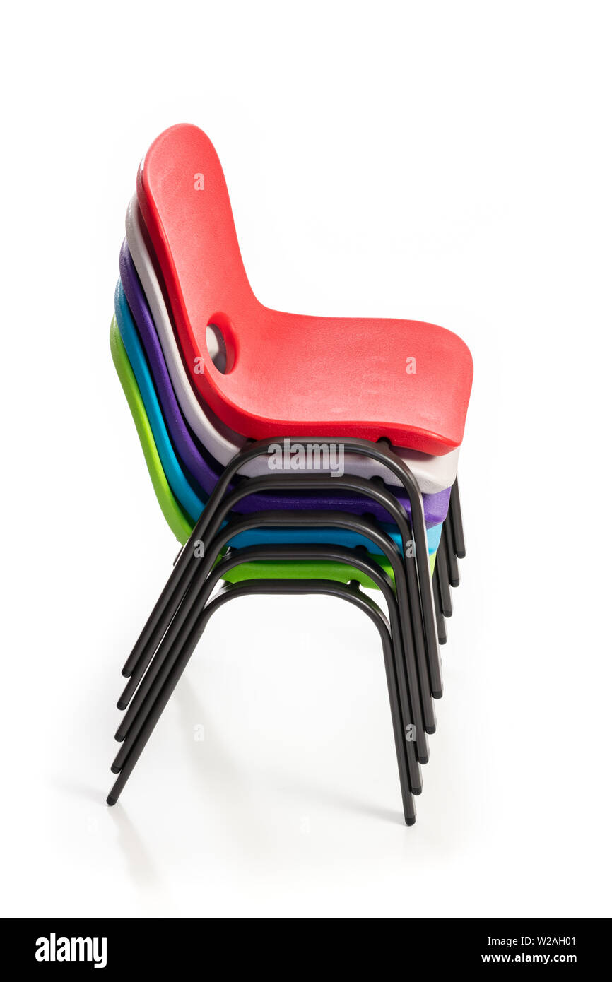 Kunststoff Stühle für Kinder der verschiedenen Farben auf weißem Hintergrund gestapelt, Seitenansicht. Stockfoto