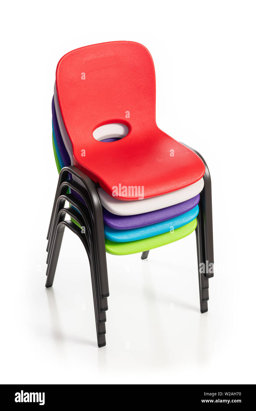 Kunststoff Stühle für Kinder der verschiedenen Farben auf weißem Hintergrund gestapelt. Stockfoto