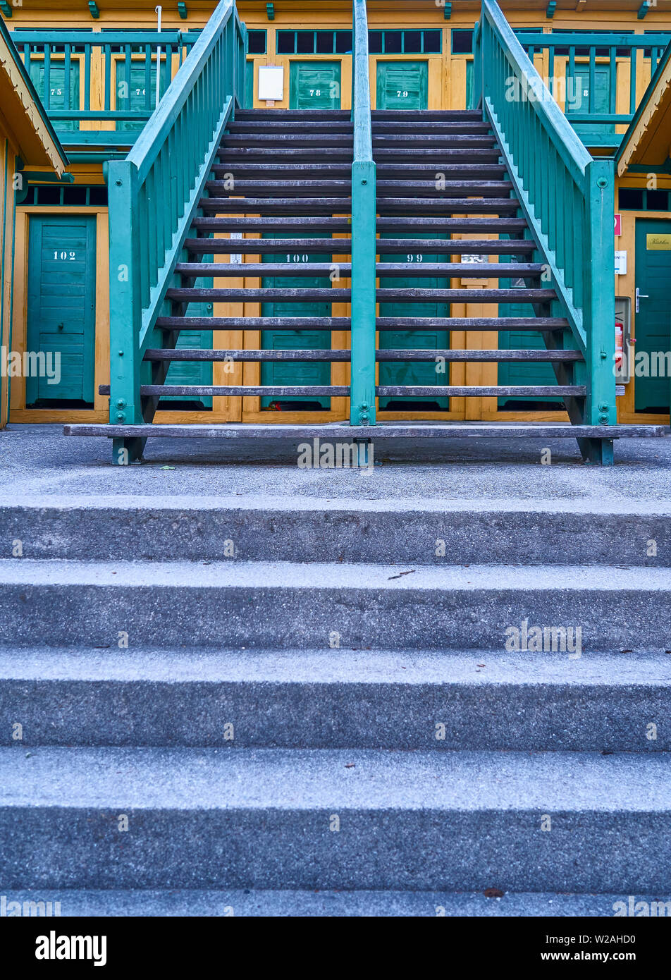 Eine Symmetrie Treppe Holzhütten im historischen natürlichen Thermalbad in Bad Fischau, Österreich. Kabinen sind für Ihre gelb/orange/grün Farben bekannt. Stockfoto