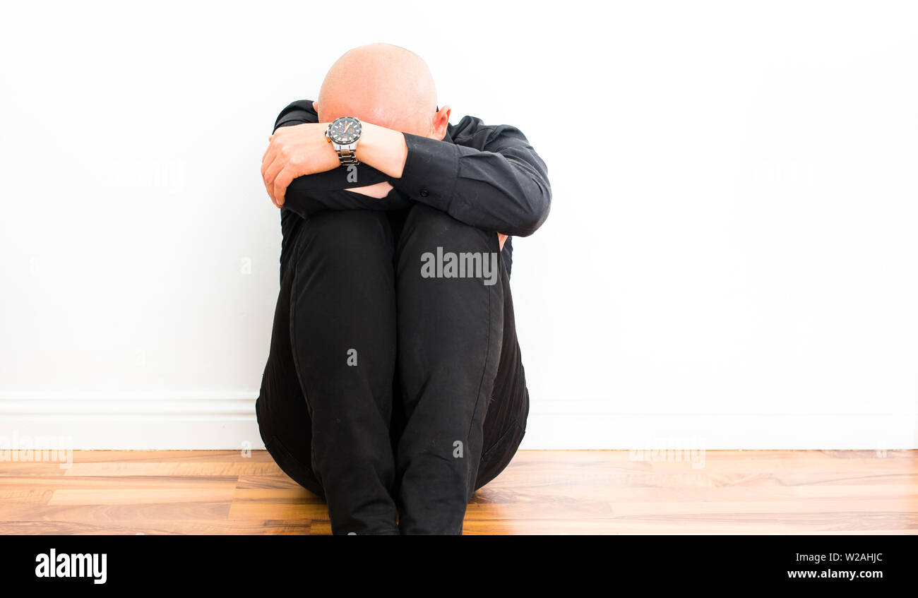Junge depressiven Mann sitzt auf dem Boden und schrie Stockfoto