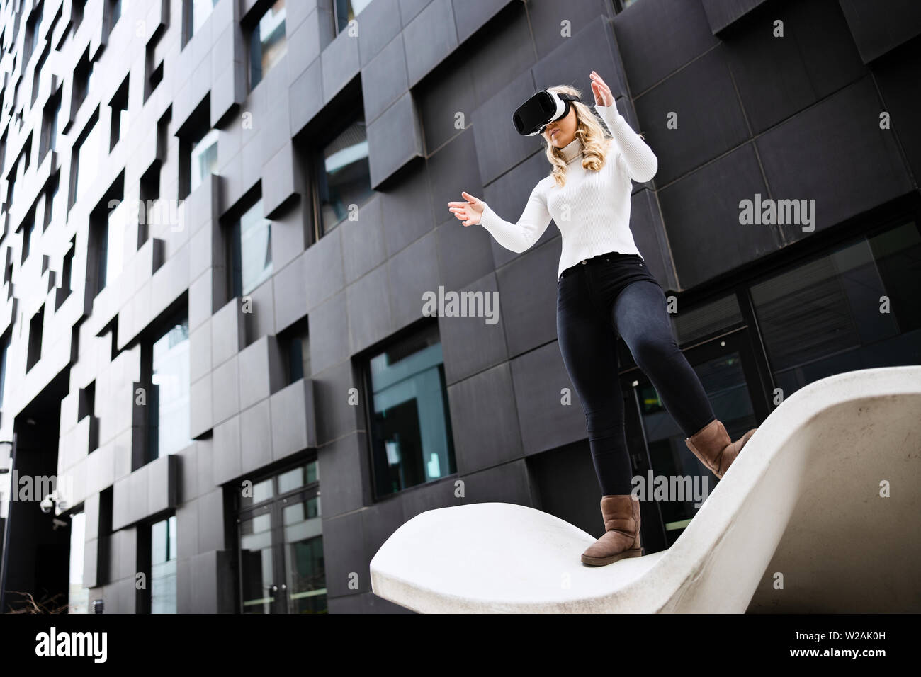 Frau mit Virtual Reality Brillen gegen Gebäude Stockfoto