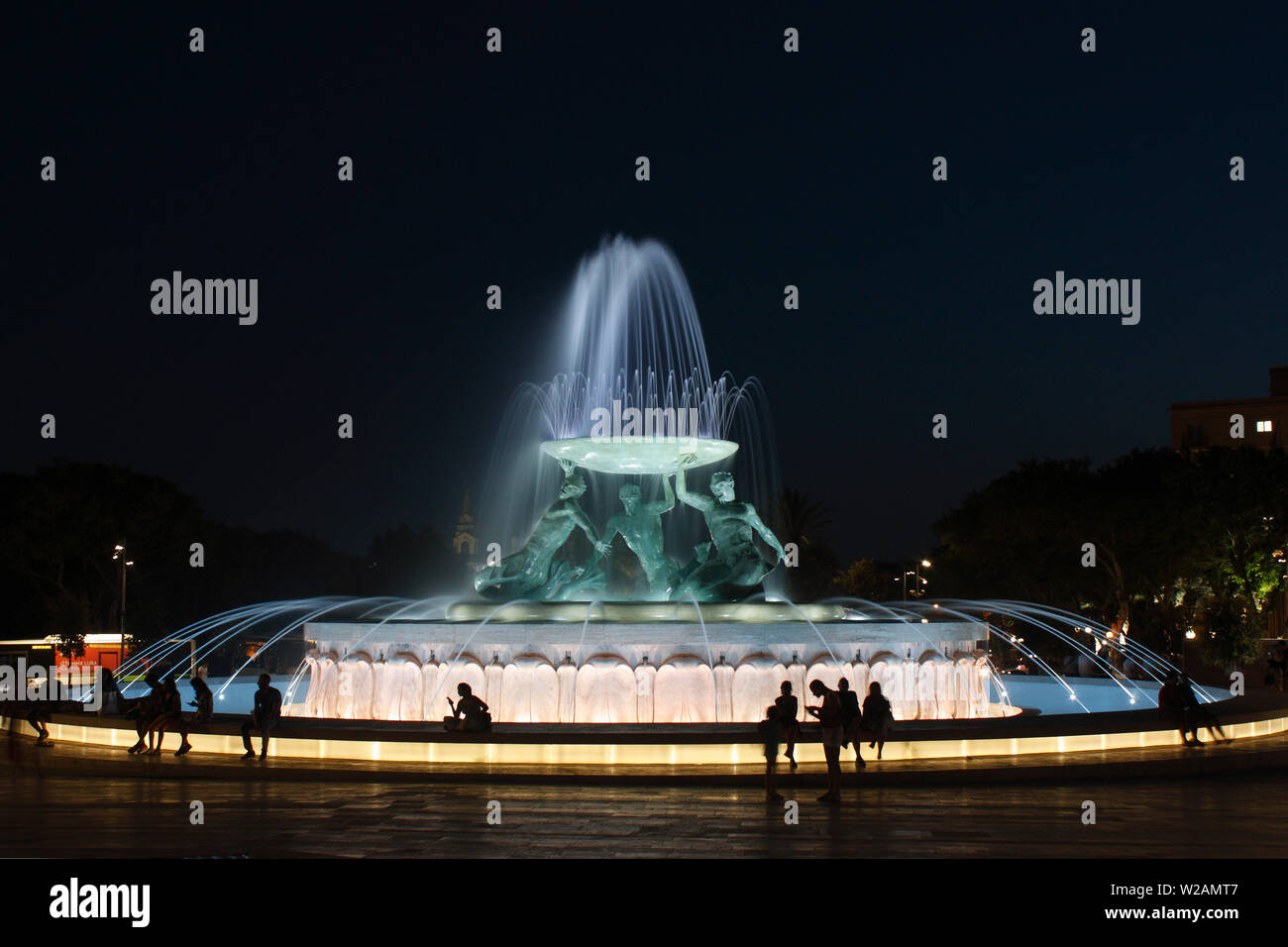 Menschen entspannend durch die Triton Brunnen am Eingang nach Valletta, Malta, beleuchtet Stockfoto