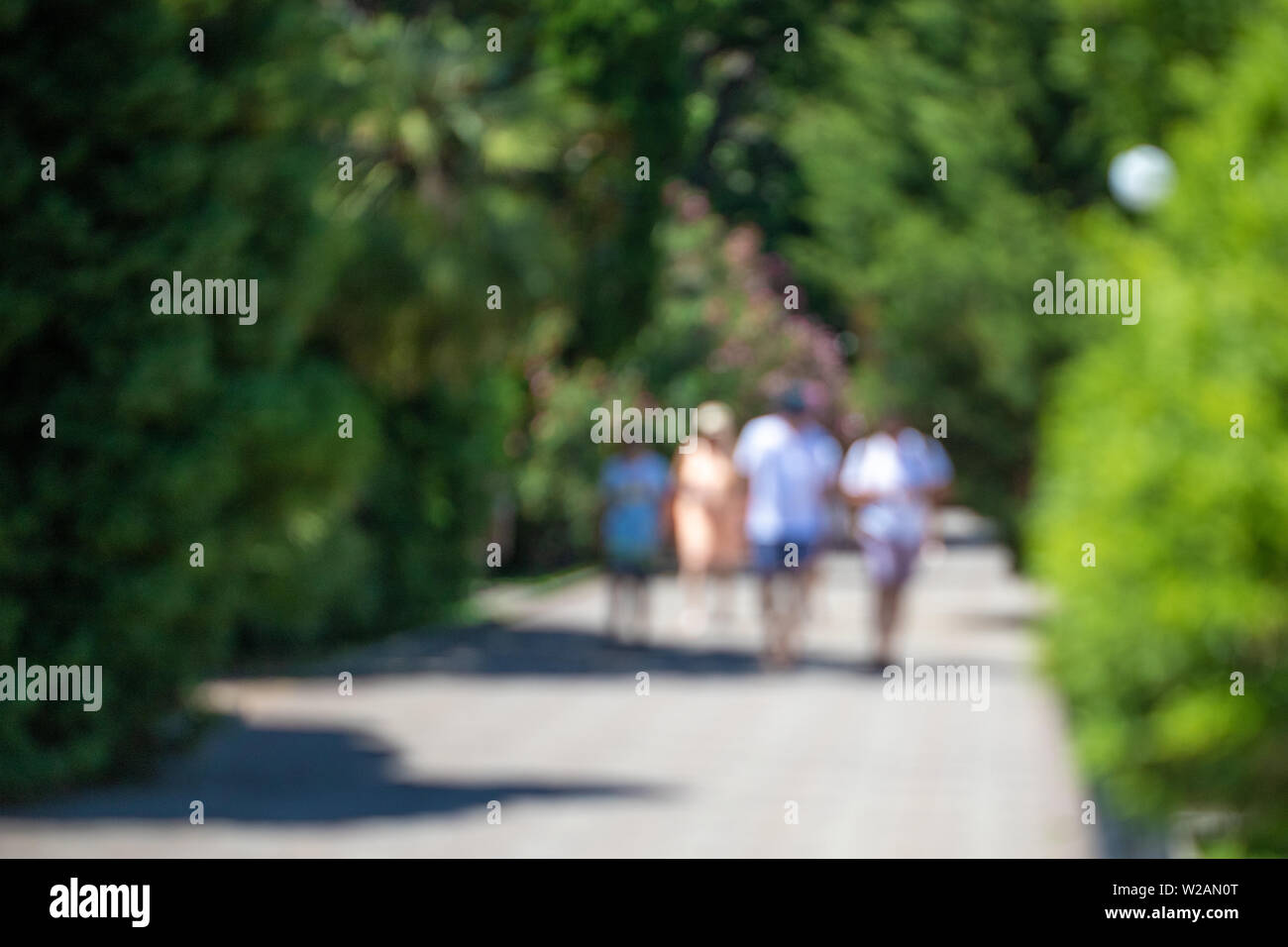Verschwommen defokussierten Menschen gehen in den Park. Stockfoto