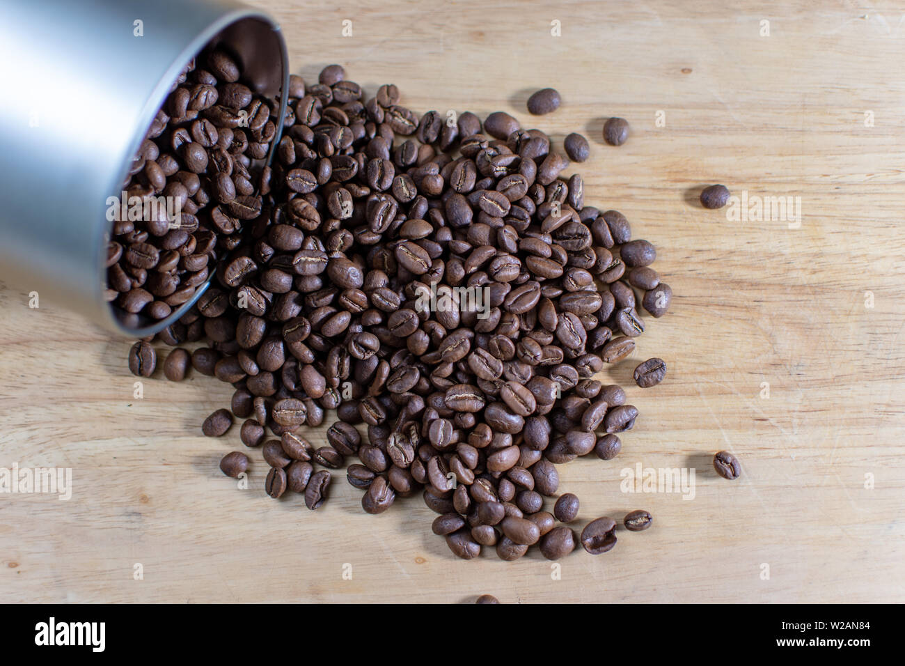 Kaffee Bohnen Verschütten aus einem rohrförmigen Metallbehälter Stockfoto