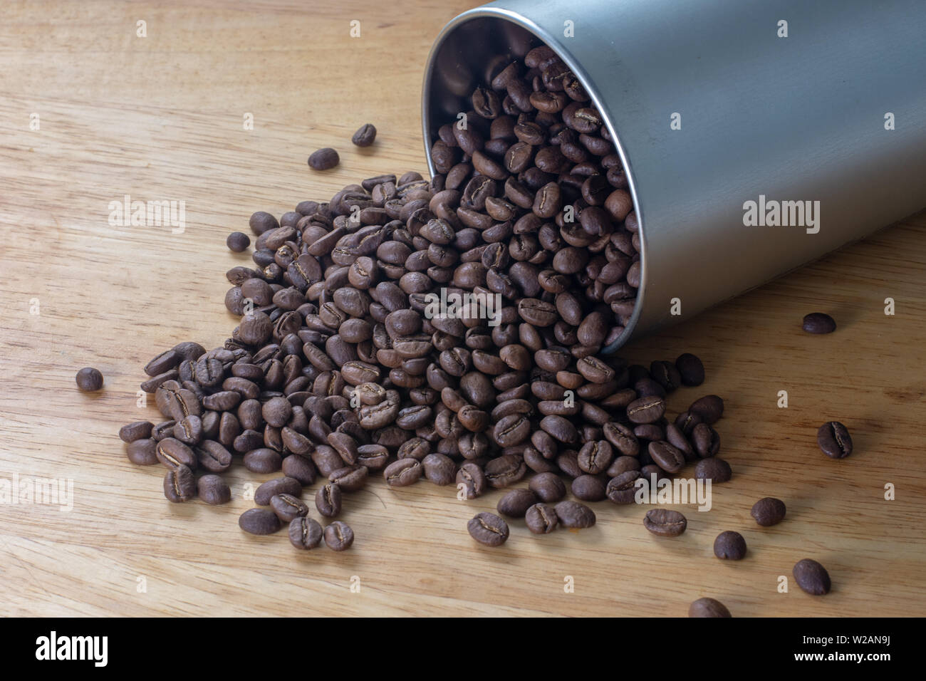 Kaffee Bohnen Verschütten aus einem rohrförmigen Metallbehälter Stockfoto