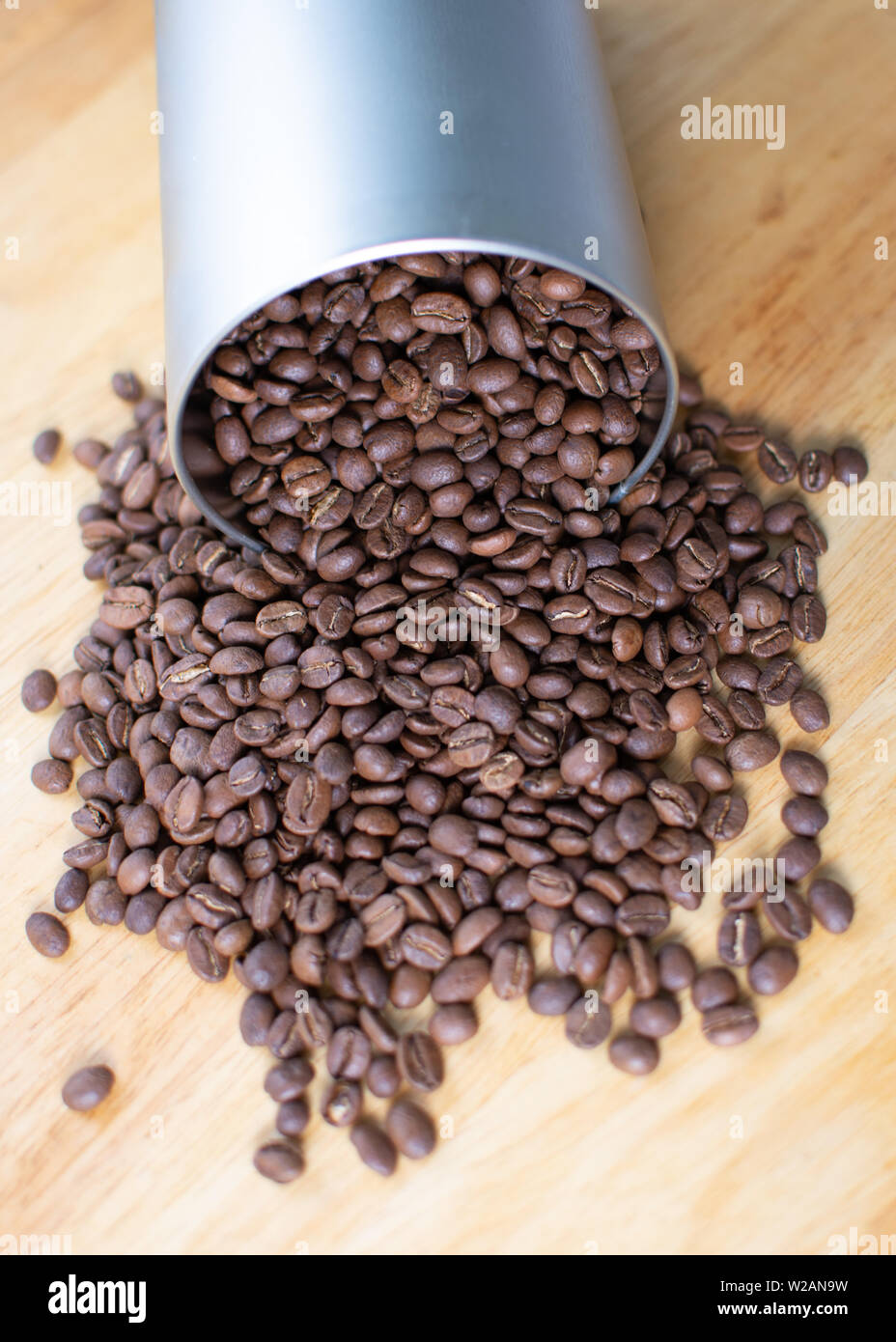 Kaffee Bohnen Verschütten aus einem rohrförmigen Metallbehälter Stockfoto
