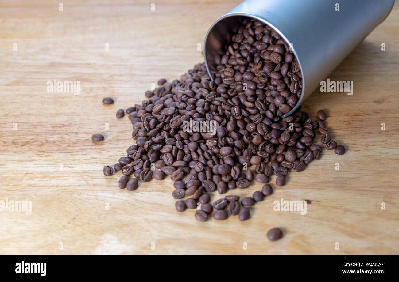 Kaffee Bohnen Verschütten aus einem rohrförmigen Metallbehälter Stockfoto