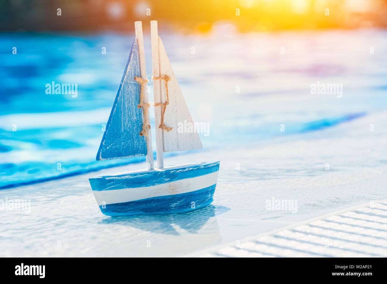 Holzspielzeug Segelboot am Pool im Sommer. Urlaub und Freizeit Konzept Konzept. Stockfoto